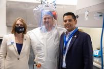 Rep. Ruiz posing with woman and man in protective suit