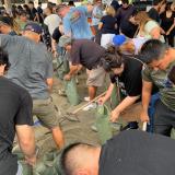 Congressman Ruiz shoveling sand with community member to fill sandbags 