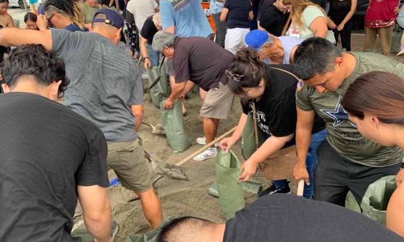 Congressman Ruiz shoveling sand with community member to fill sandbags 